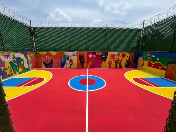 Cancha de fútbol rápido con pasto sintético de colores y murales