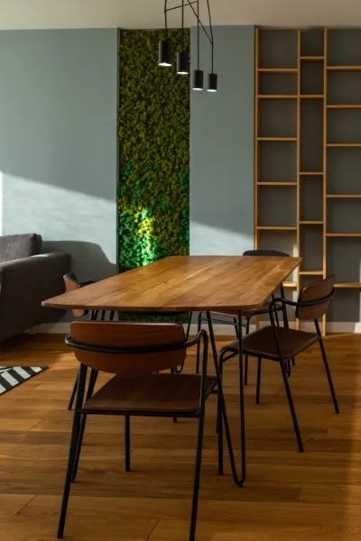 Muro verde con diseño minimalista en apartamentos o en una oficina rústica con librero y mesa de madera